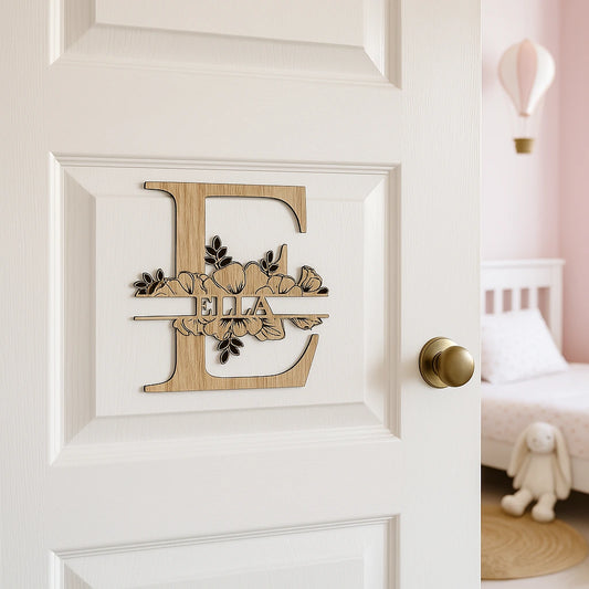 Monogramme en bois représentant la lettre E avec le prénom "Ella", décoré de fleurs de coquelicot, fixé sur une porte blanche de chambre d’enfant – décoration murale personnalisée et poétique.